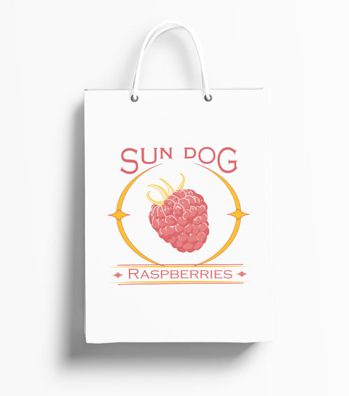 White handled shopping bag with logo for the company Sun Dog Raspberries. Features a raspberry in the center of a circular sun flare known as a sun dog.