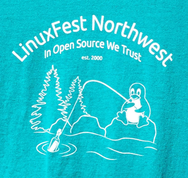 T-shirt with LinuxFest Northwest arched over a scene with a penguin fishing with a fishing pole, pulling a bottle with a message out of the water.